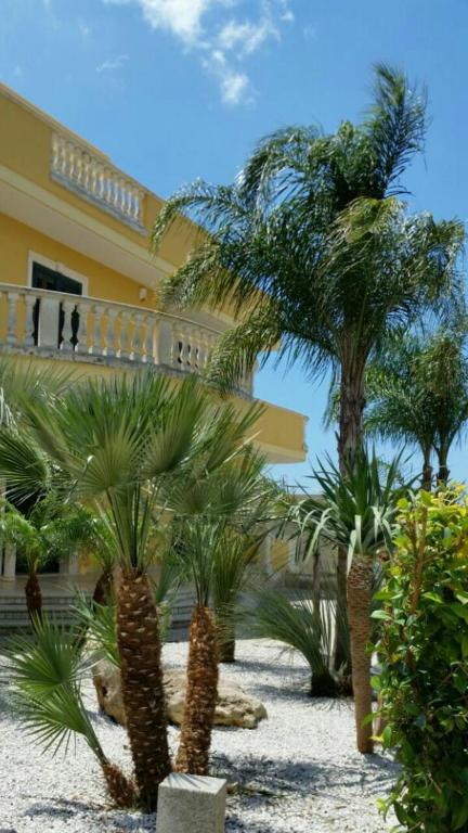 加利波利Villa Belvedere di Rita的一座棕榈树度假村,位于一座建筑前