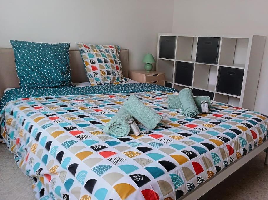 昂蒂布100m des plages centre Antibes的一张大床,配有色彩缤纷的被子和枕头
