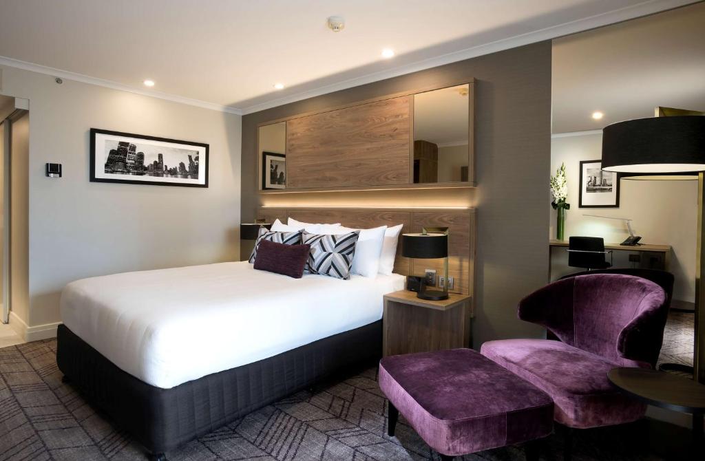 布里斯班布里斯班雷吉斯南岸酒店的配有一张床和一把椅子的酒店客房