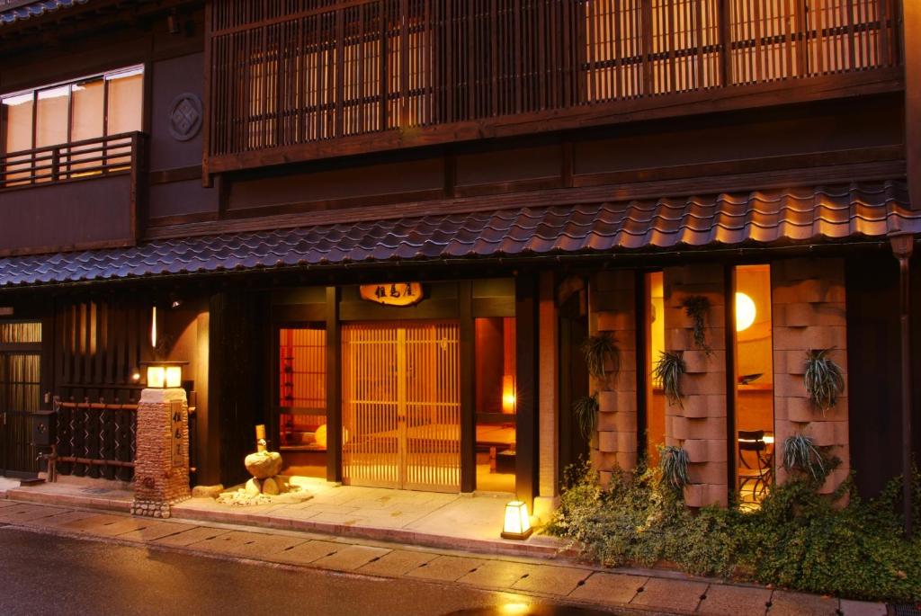 丰冈市城崎温泉 但馬屋-Tajimaya-的夜间有灯的建筑物入口