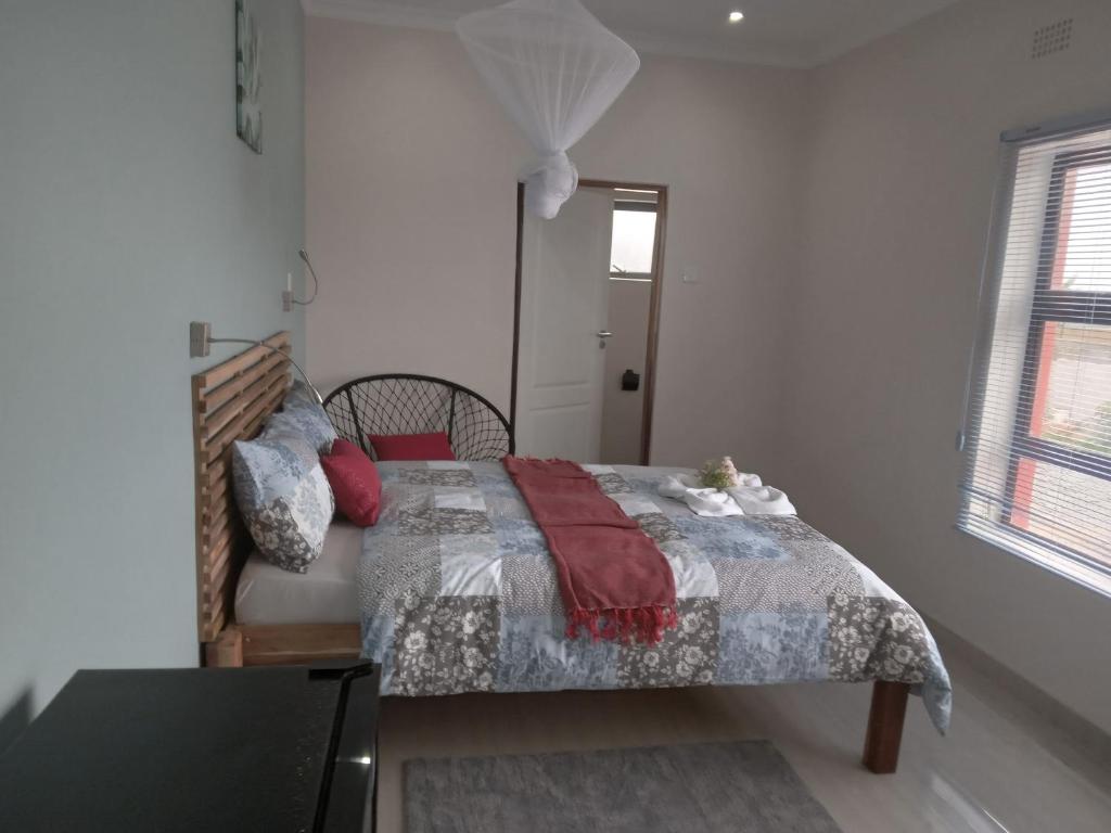 MzuzuChaya accommodation B&B and self catering的一间卧室配有一张带毯子的床和窗户