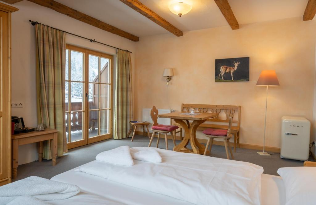 基茨比厄尔附近奥拉赫Gasthof Auwirt的卧室配有一张床和一张桌子及椅子