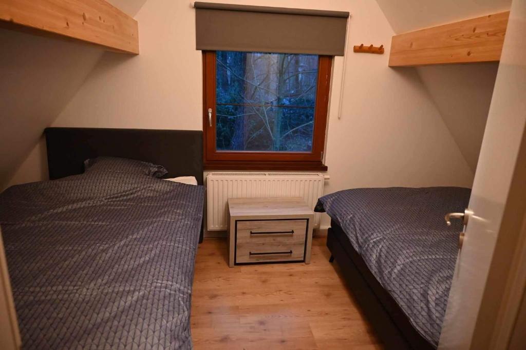 BovenwezetKom tot rust midden de natuur! Top Locatie! Top Deal!!的一间卧室设有两张床和窗户。