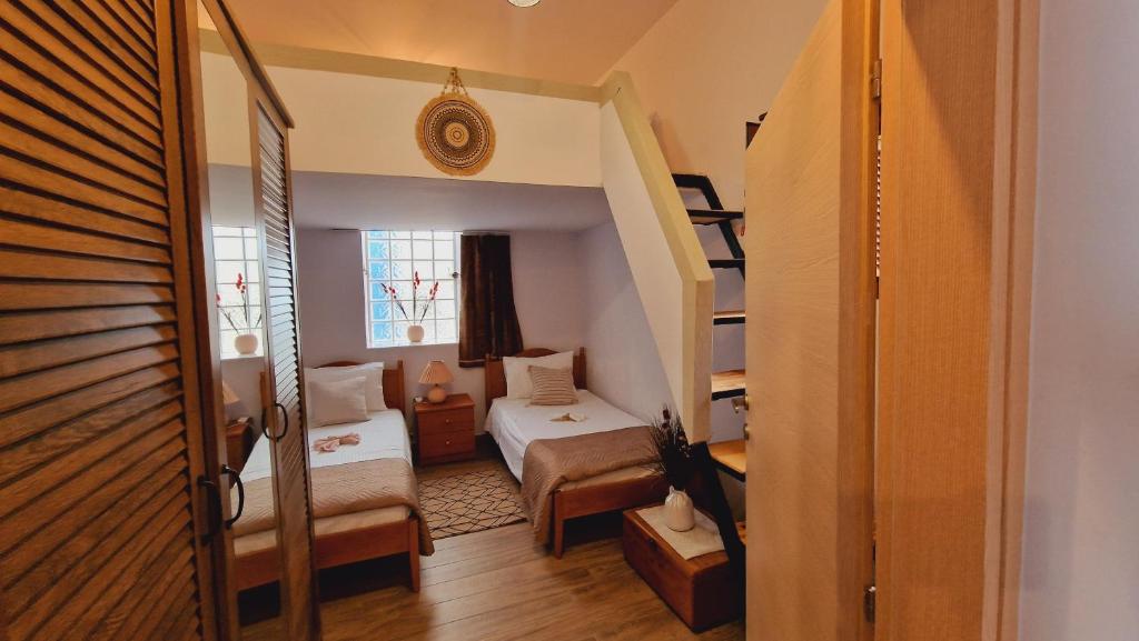 MonólithosSeva Monolithos house的小房间设有床和楼梯