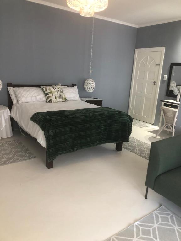 莱登堡Kellys Corner的一间卧室配有一张带绿毯的床
