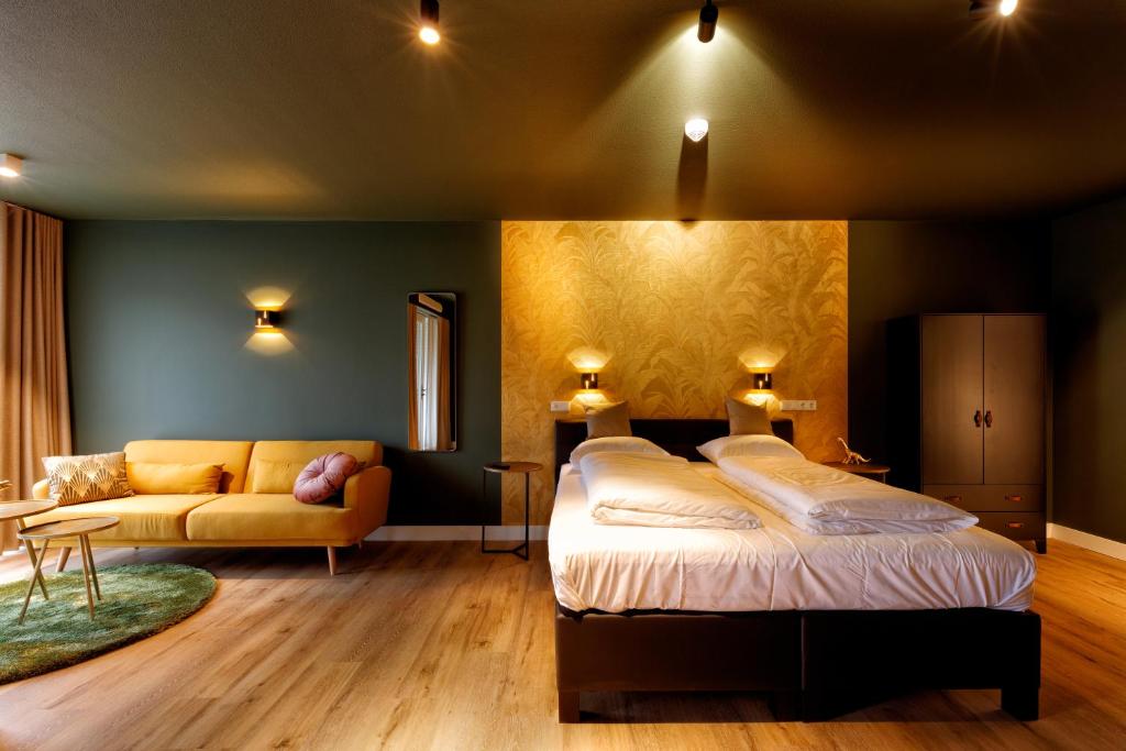 亨厄洛Wapen van Hengelo Residence Suites - digital key by email的一间卧室配有一张床和一张沙发