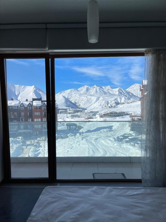 古多里Happy Holidays Apartments in New Gudauri的从窗户可欣赏到白雪 ⁇ 的山景