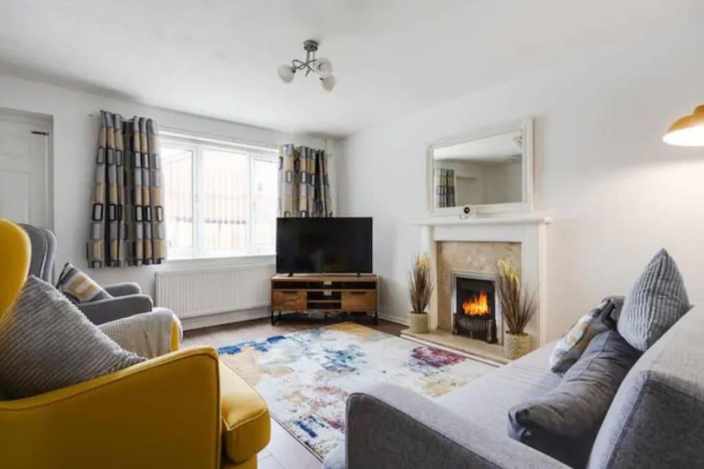曼彻斯特Newly renovated house near Trafford Centre的客厅设有两张沙发和一个壁炉