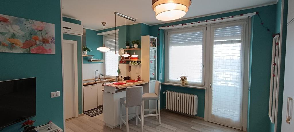 库尼奥L'alloggetto sul Corso的厨房设有绿色的墙壁和桌椅