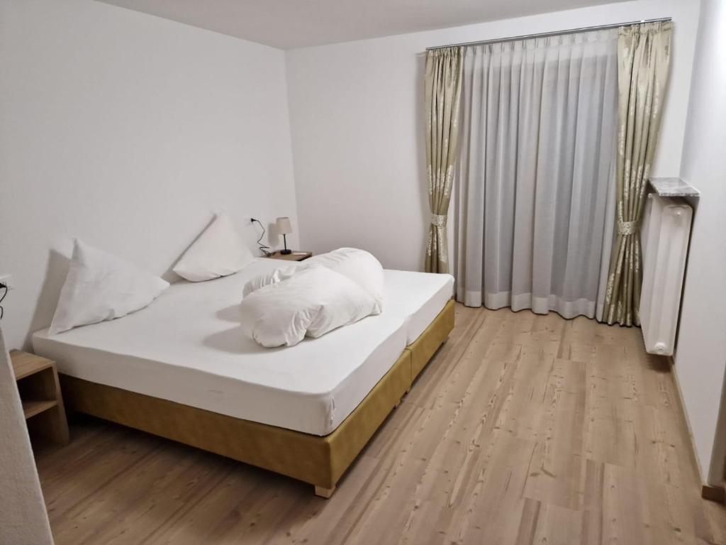 奥蒂塞伊Apartment Aghel的一间卧室配有一张铺有木地板的白色床单。