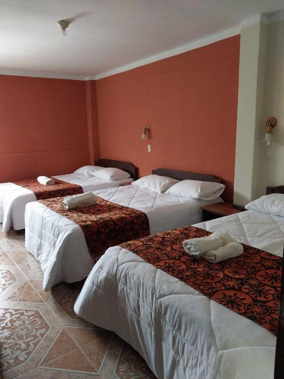 ValeraMonte Gocta的红色墙壁的房间里设有三张床
