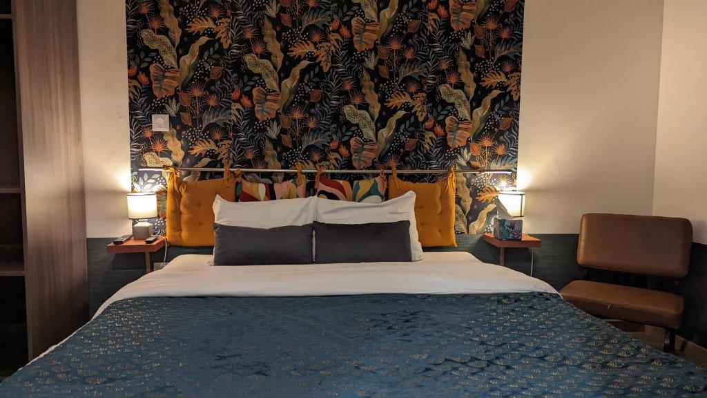 塞纳河畔诺让Aux Écuries Des Pres的一间卧室配有一张带花卉壁纸的大床