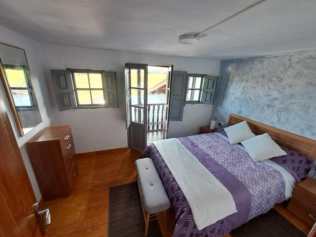 圣维森特-德拉巴尔克拉La Corralada de Merón的一间卧室配有紫色的床和窗户墙