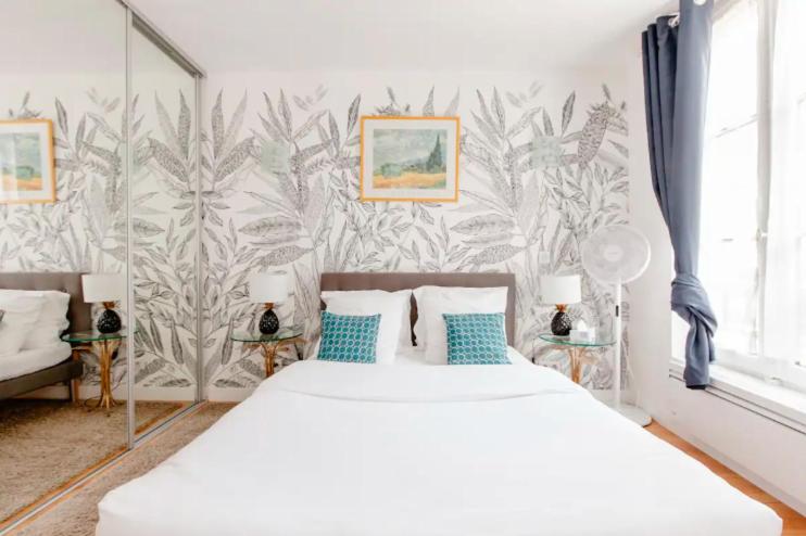 凡尔赛Le Studio Versaillais的一间卧室配有白色床和蓝色枕头