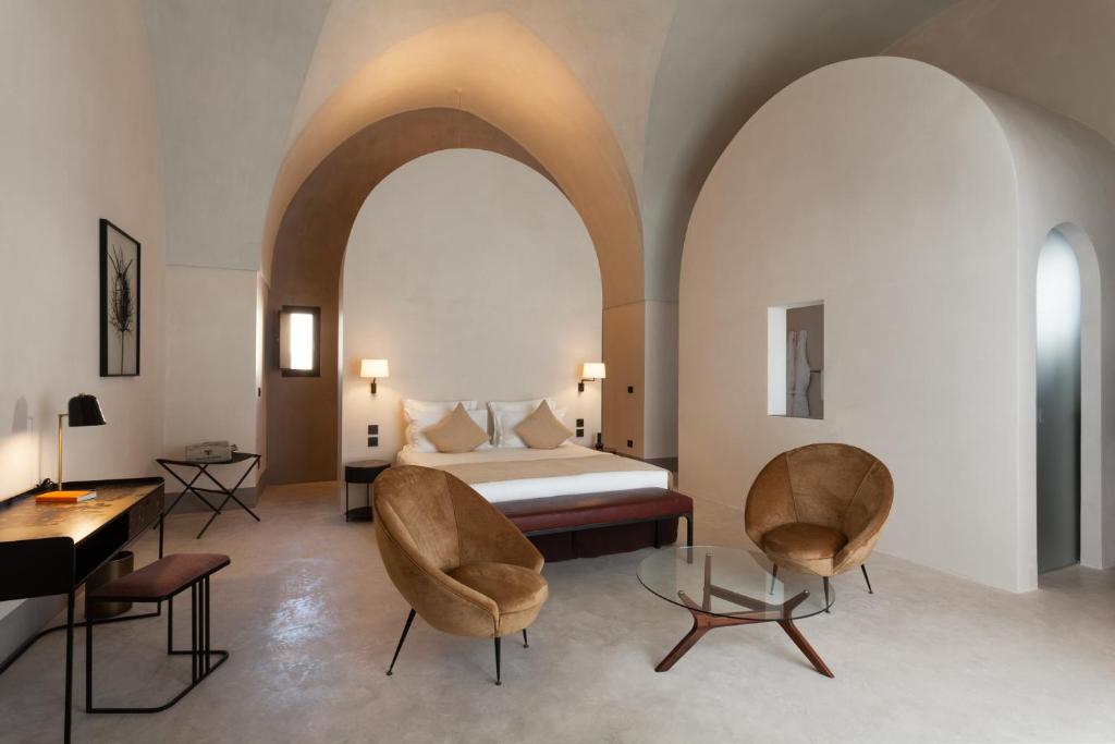 纳尔多Palazzo Tafuri的一间卧室配有一张床、两把椅子和一张桌子