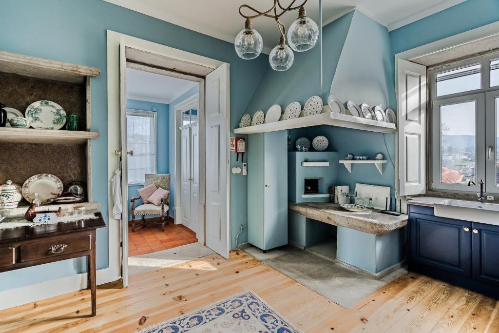 卡米尼亚Casa da Avó的蓝色的厨房,配有水槽和窗户