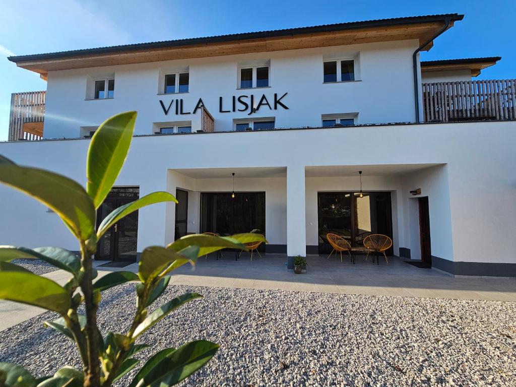 博德森特克VILA LISJAK - Apartments的一座白色的建筑,上面有读写维瓦岛的标志