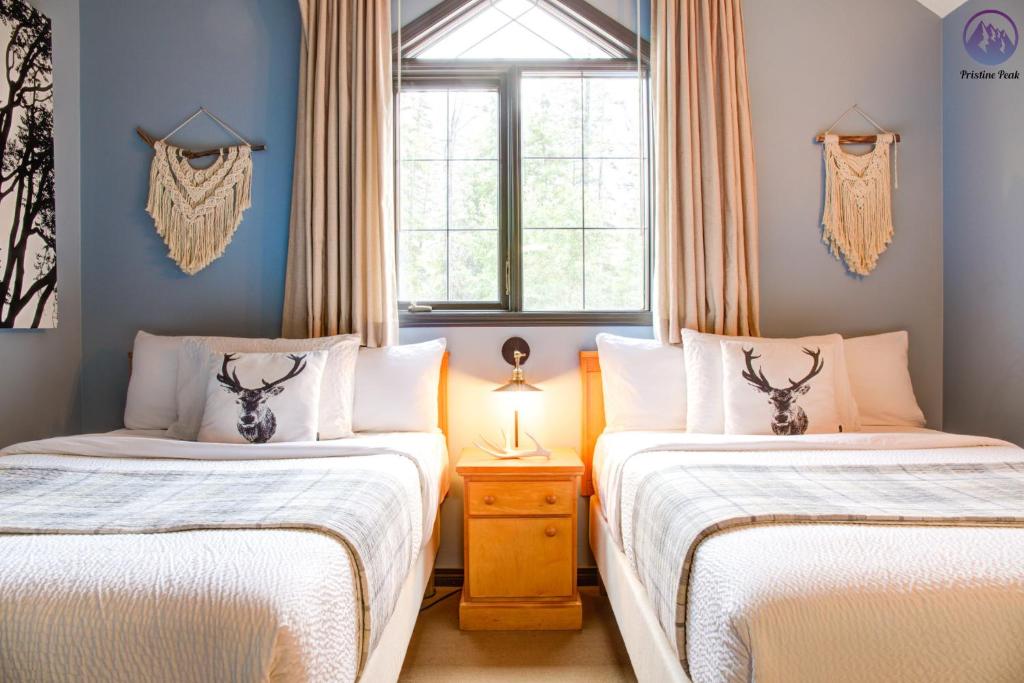 坎莫尔Grotto Canyon Chalet的一间卧室设有两张床和窗户。
