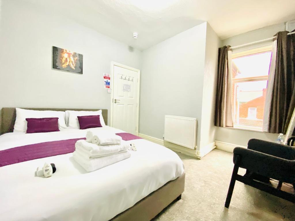布莱克浦Blackpool - Seaside的一间卧室设有两张床、一把椅子和一个窗户。