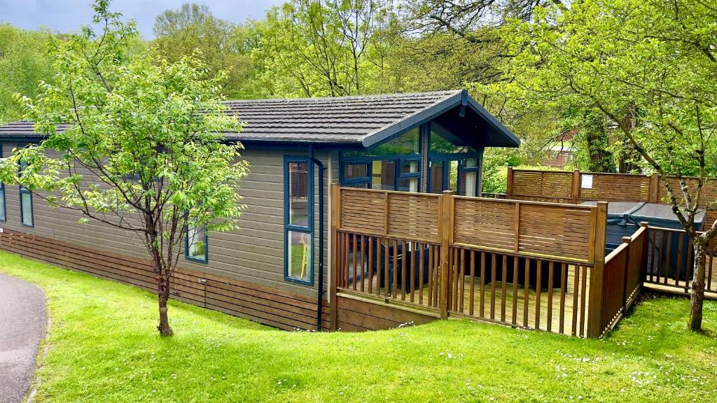 查德利Beautiful Oak Cabin in Devon Finlake Resort Spa的一座带木甲板和庭院的房子