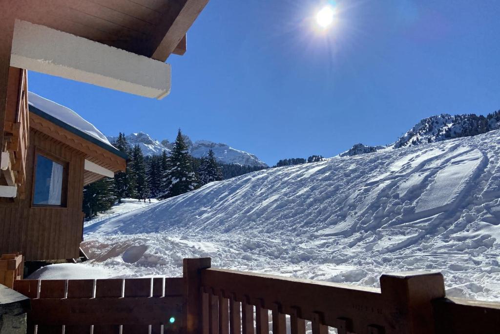 谷雪维尔Cosy and spacious family nest with superb view的一座房子旁边的雪覆盖的山丘