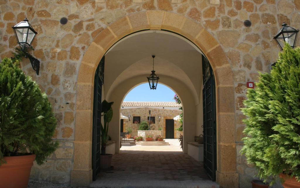 桑布卡迪西奇利亚唐璜酒店的一座有盆栽植物的建筑中的拱门