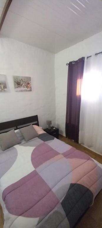 TaibiqueCasa de María del Pilar的一间卧室配有一张大床和色彩缤纷的毯子