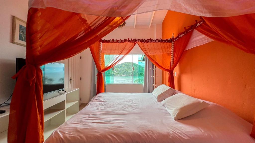 巴拉-沙希Casa com vista a praia da Barra do Sahy的一间卧室配有一张带橙色墙壁和窗户的床