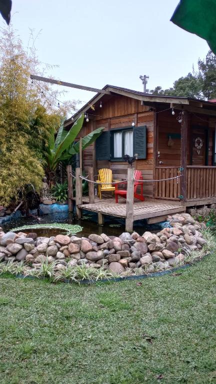 坎普阿莱格里Chalé Cafofo的小木屋,设有甲板和庭院内的池塘