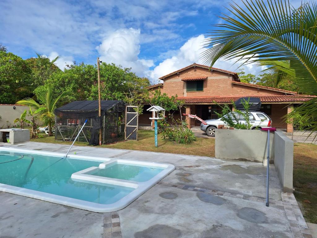 Costa DouradaCasas lindas no paraiso!的一座带房子的庭院内的游泳池