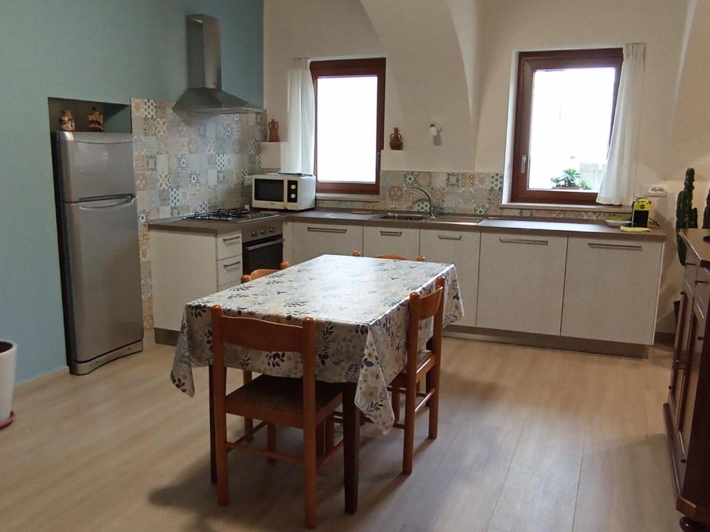 库尼奥La Casa di Abe - Cuneo的厨房配有桌椅和冰箱。