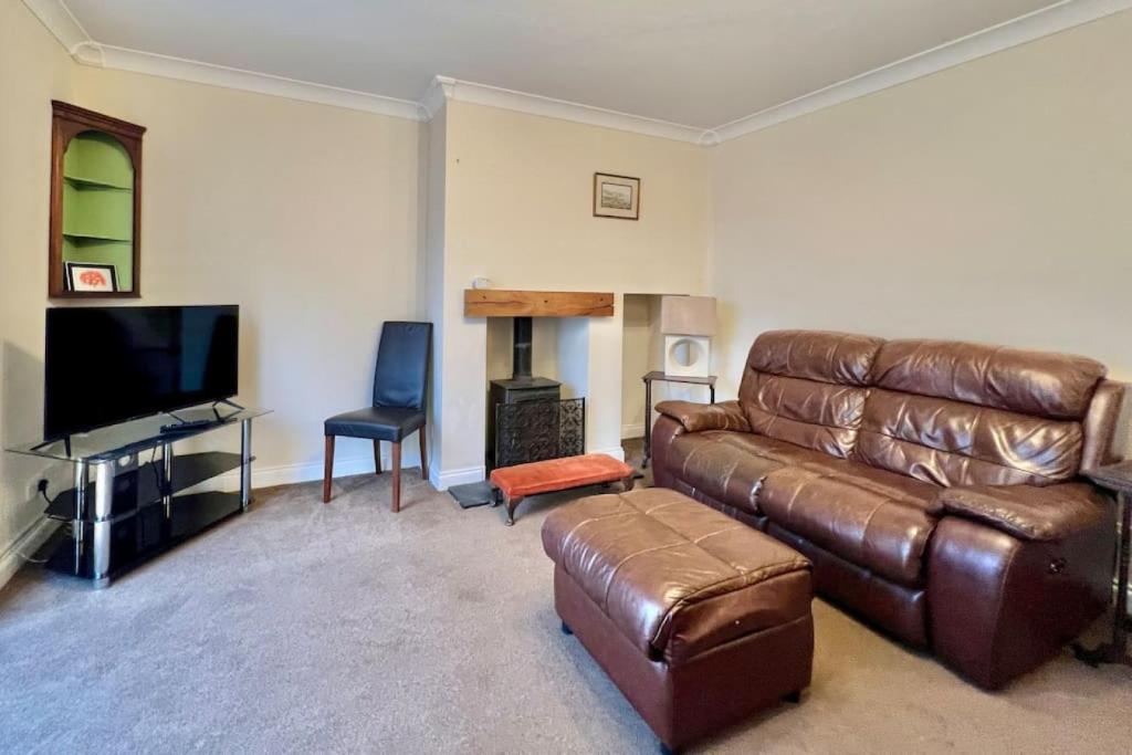 DeanFantastic central home的客厅配有真皮沙发和平面电视