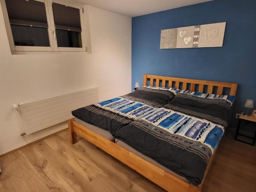 布克斯Ahornzimmer, ruhige Lage, nähe Bahnhof und Zentrum的卧室内的一张床铺,卧室内有蓝色的墙壁