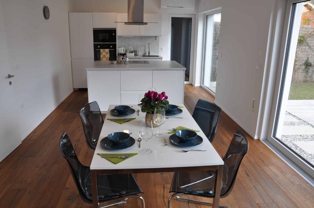 卢布尔雅那Apartments Trnovo的白色桌椅和白色厨房