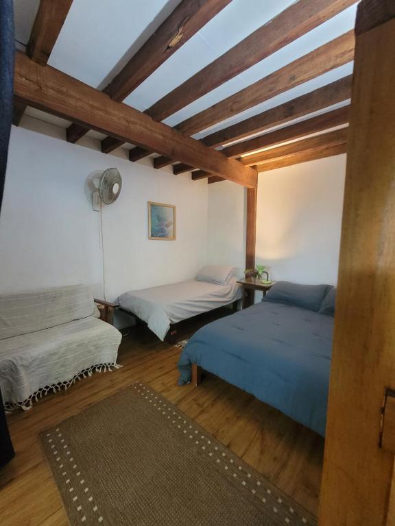 La AguadaCasa Encantada Guest House的配有木天花板的客房设有两张床。