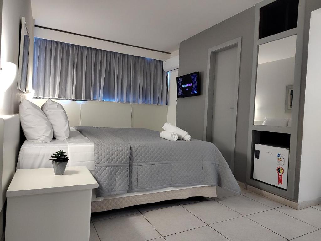 贝洛奥里藏特Hotel Oscar Gold Savassi的酒店客房,配有床和电视