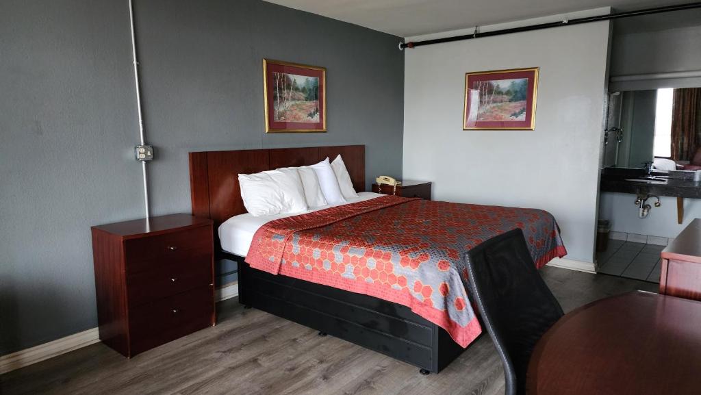 兰辛Starway Inn的酒店客房配有一张床铺和一张桌子。