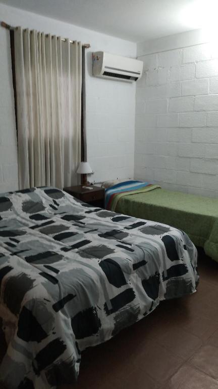 萨尔塔CasaTribuno的一间设有两张床的客房,位于一个设有床铺的房间内