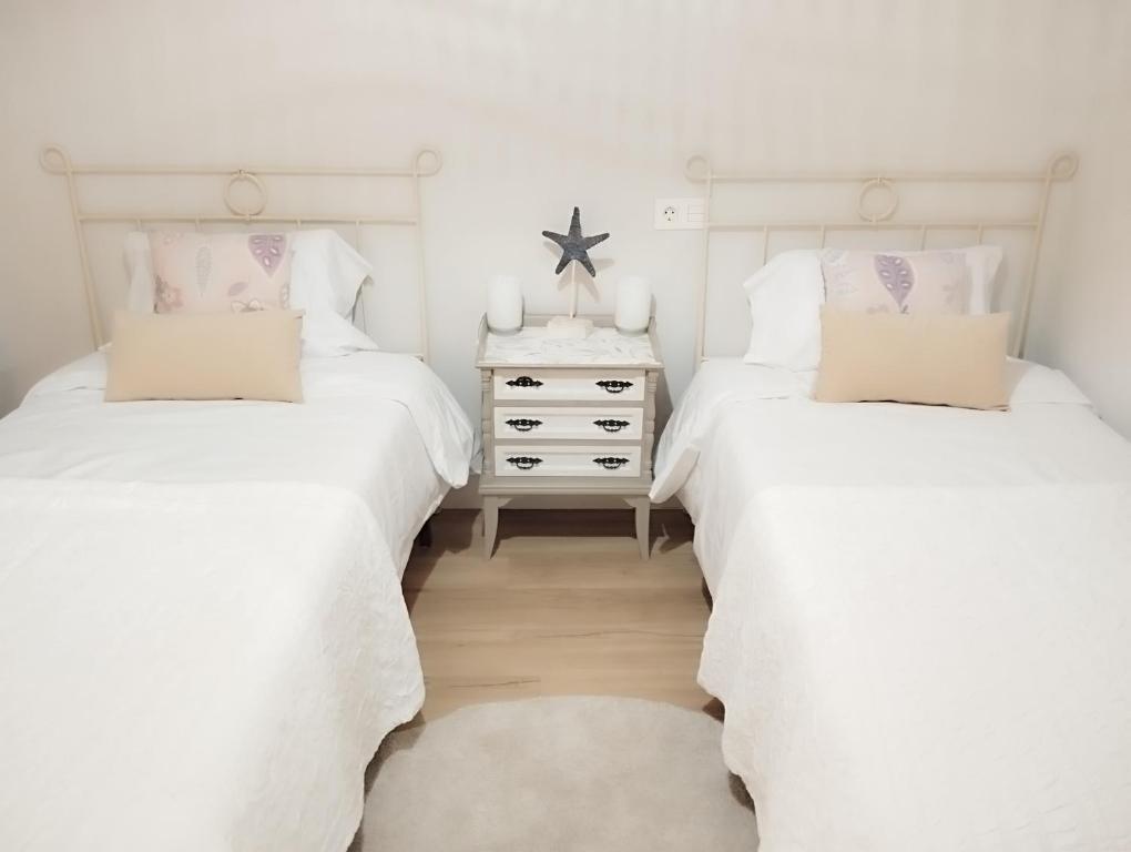 希洪El Hogarin de Veronica的卧室设有两张单人床和床头柜