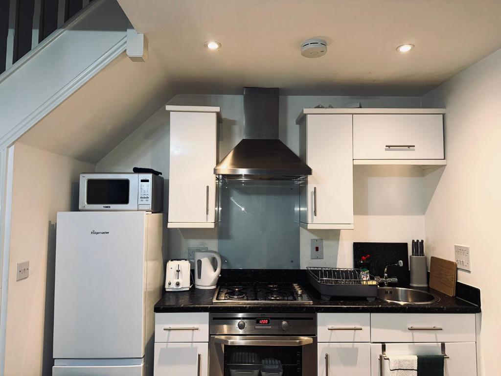 Sherborne Saint JohnGuest House Nikol的厨房配有炉灶和微波炉。