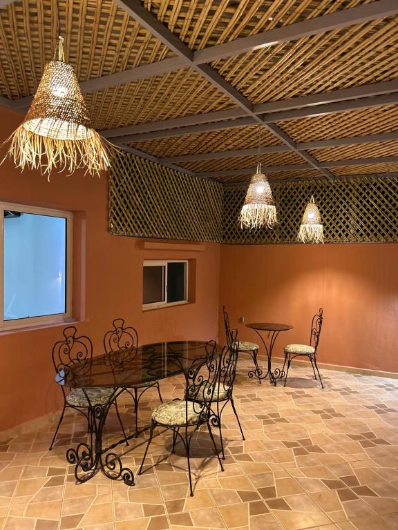 马拉喀什Appartement Duplex élégant et calme Marrakech Menara的用餐室配有桌椅和灯