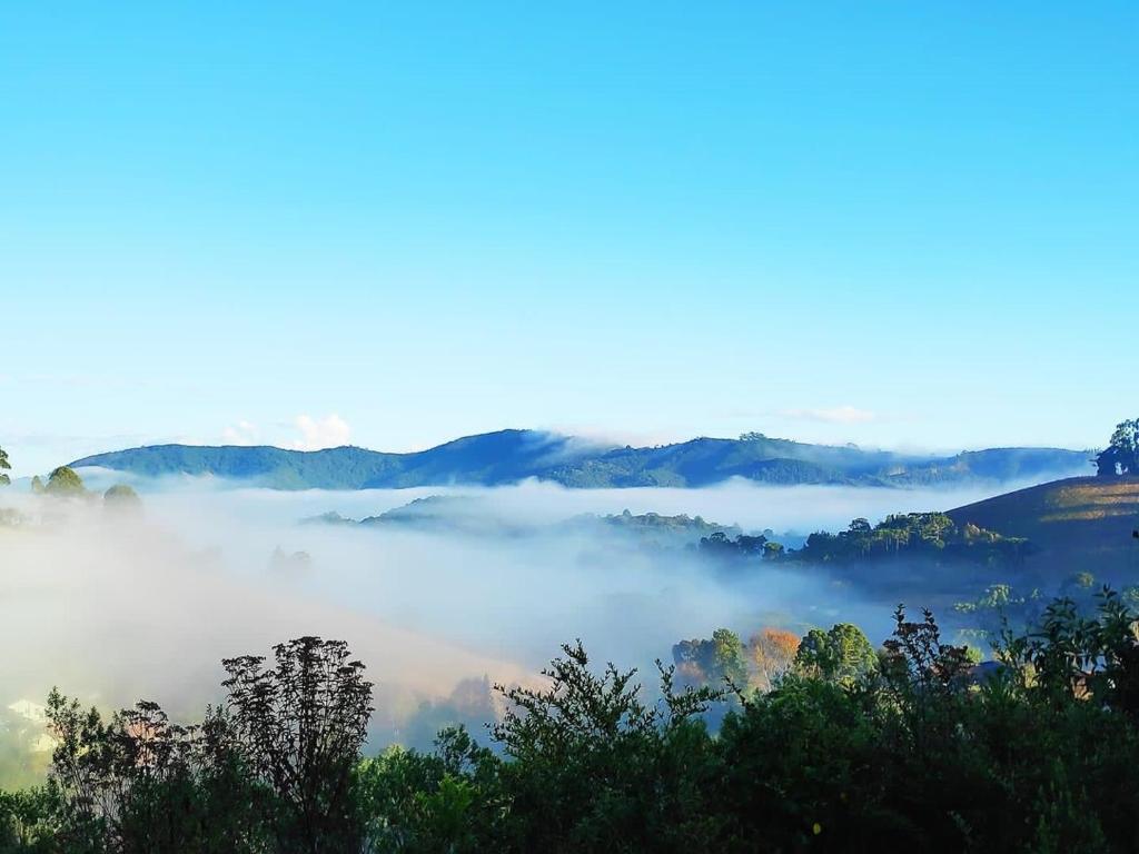 蒙特韦尔迪Chales Boa Vista的享有树木和山脉的雾 ⁇ 山谷美景