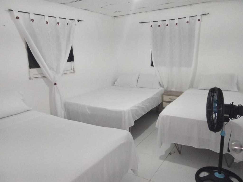 巴兰基亚HOSTAL BARRANQUILLA INN的一间房间,带三张床和摄像头