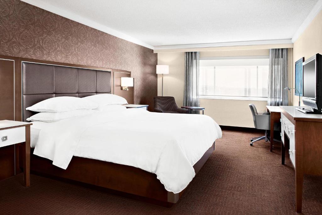 拉瓦尔拉瓦尔喜来登酒店 的酒店客房设有一张大床和一张书桌。