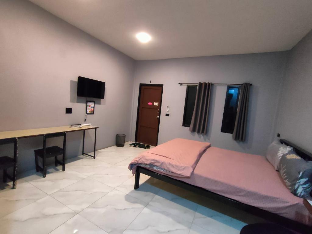Chai Natเช็คอินรีสอร์ท Check-in Resort的一间卧室配有一张床和一张书桌