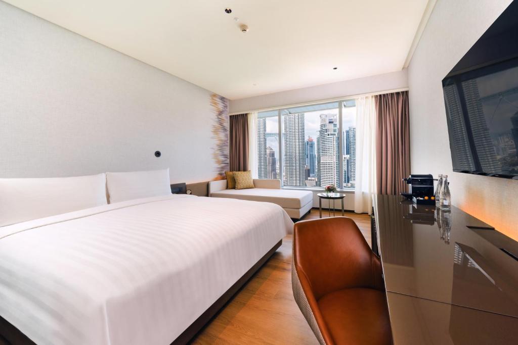 吉隆坡吉隆坡盛贸饭店的卧室配有一张白色的大床和一张沙发。