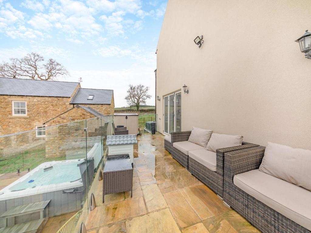 毕晓普奥克兰Binchester Crag Farm的阳台配有沙发和热水浴池。