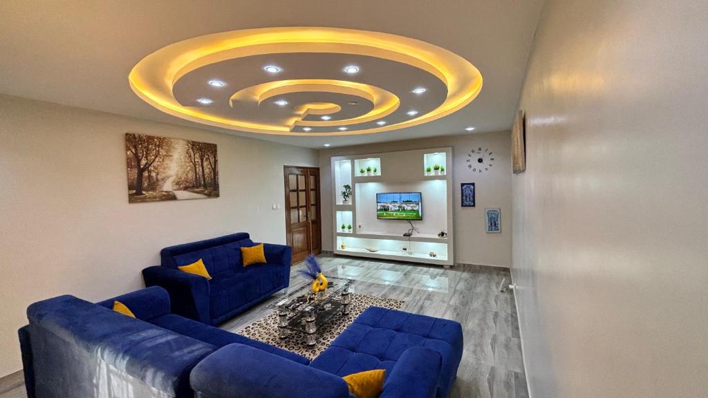 达喀尔Magnifique appartement meublé à Dakar, Rte de Rufisque的客厅设有蓝色的沙发和金色天花板