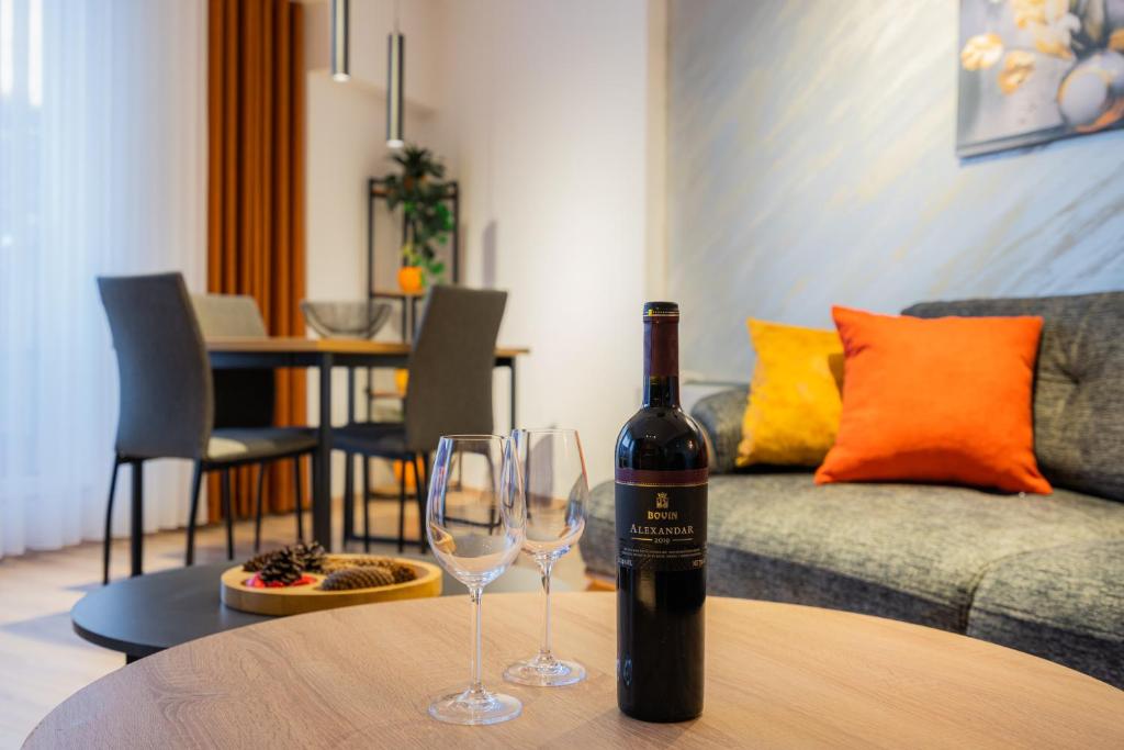 马夫罗沃Lynx Apartment的桌子上放有一瓶葡萄酒和两杯酒