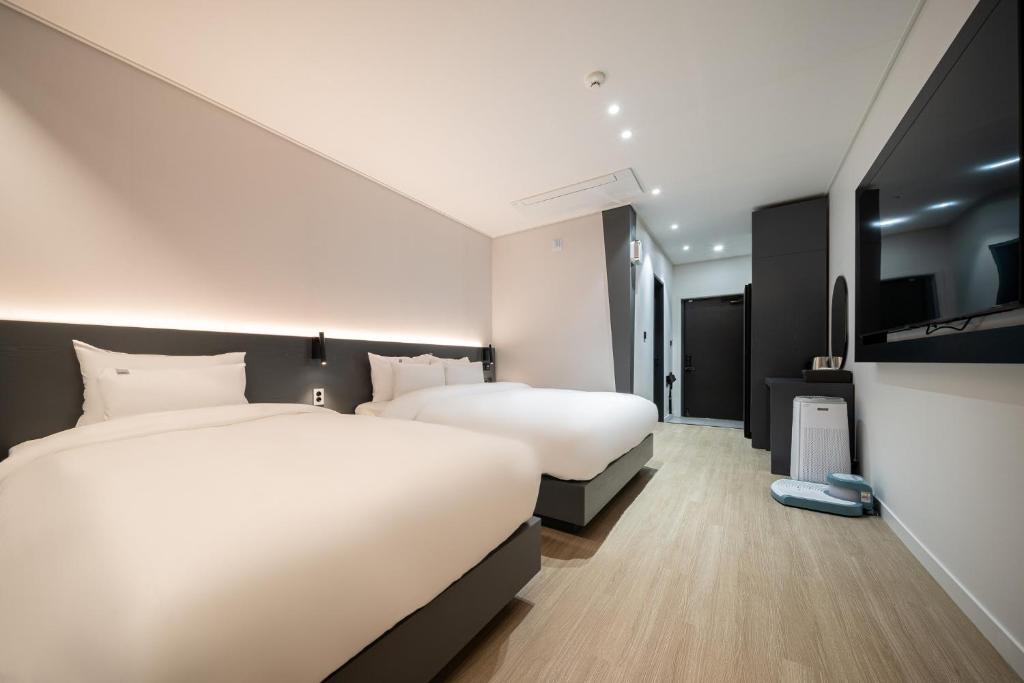 木浦市Hound Hotel Mokpo Peace Plaza的一间酒店客房,设有两张床和电视
